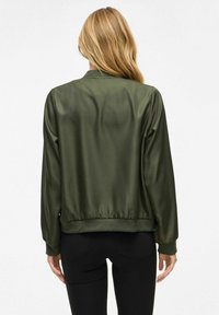 Giacca bomber in satin verde oliva con maniche lunghe, polsini e orlo a costine, texture liscia, senza logo o motivi visibili.