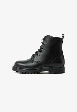 Stivali alla caviglia in pelle nera con lacci frontali, punta rotonda, suola texture e un anello sul tallone per una facile calzata.