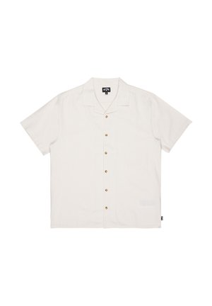 Koszula na krótki rękaw na guziki w kolorze kremowym, wykonana z lekkiego materiału. Posiada kołnierz z wycięciem oraz brązowe guziki, z subtelnym detalem kieszeni.