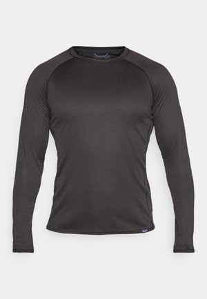 Zwarte lange mouw shirt van textuurstof; heeft een ronde halslijn en contrasterende stiksels langs de naden.