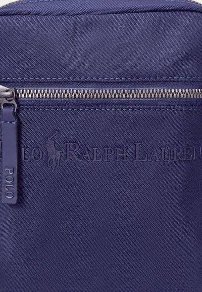 Rucsac din nylon bleu marin, cu țesătură texturată, buzunar frontal cu fermoar și logo-ul "Polo Ralph Lauren" embosat. Detalii cu fermoar metalic argintiu.
