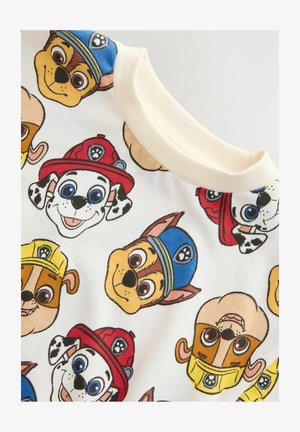 Kokvilnas T-krekls ar krāsainām multfilmu suņu sejām, tostarp ugunsdzēsēju ķiveri, uz balta fona. Arapa noņemams ar mīkstu tekstūru.