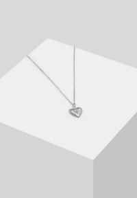 Sølv halskæde med et hjertformet vedhæng, der har et blomstermotiv og perle-accenter, hængende på en delikat kæde.