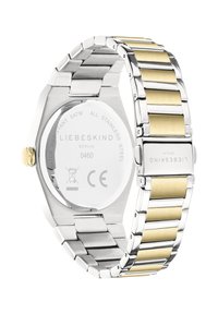 Stålur med oktagonal klockkåpa, länkarmband i silver och guldton, polerade och borstade ytor, samt ingraverad branding.