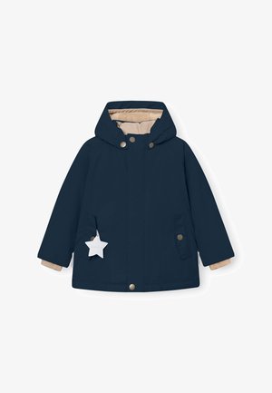 Marineblaue Jacke mit Kapuze, beiger Innenfutter, Druckknöpfen und zwei Vordertaschen. Mit einem sternförmigen Anhänger, der an der linken Tasche befestigt ist.