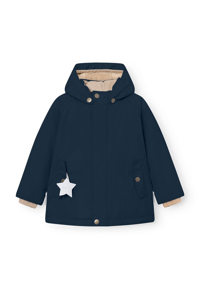 Marineblaue Jacke mit Kapuze, beiger Innenfutter, Druckknöpfen und zwei Vordertaschen. Mit einem sternförmigen Anhänger, der an der linken Tasche befestigt ist.