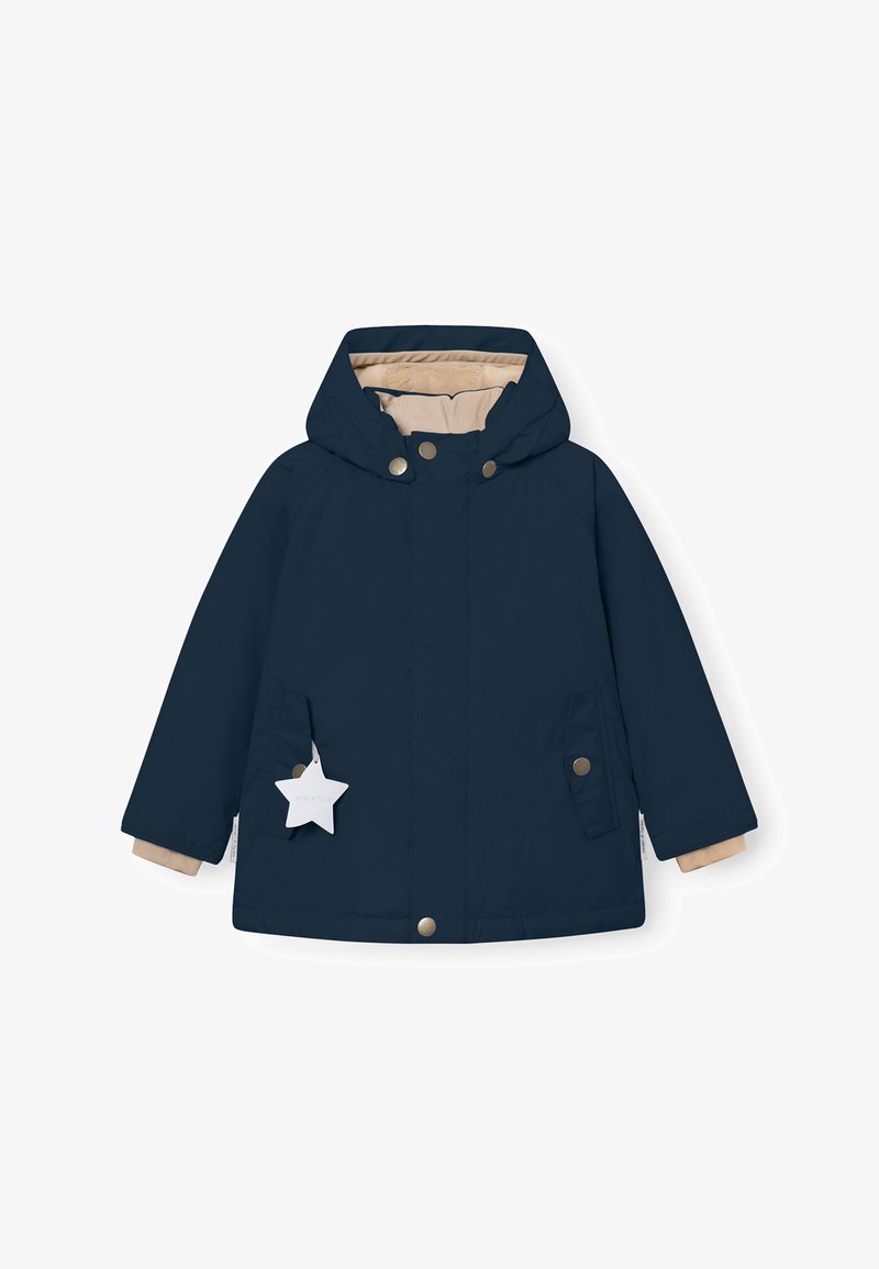 Marineblaue Jacke mit Kapuze, beiger Innenfutter, Druckknöpfen und zwei Vordertaschen. Mit einem sternförmigen Anhänger, der an der linken Tasche befestigt ist.