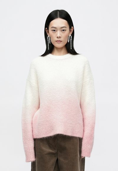 Pull en tricot dégradé passant de blanc à rose pâle, avec un col rond et des manches longues. Tissu doux et texturé.