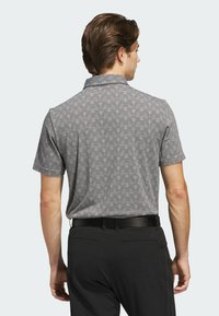Gray and black striped polo shirt with a collar, paired with black pants. Smooth texture, short sleeves, and no visible logos or embellishments.