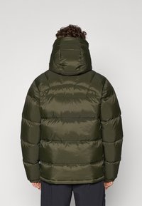Veste matelassée vert olive avec capuche, présentant un design à carreaux horizontal, une texture douce et une fermeture à pression à l'avant.