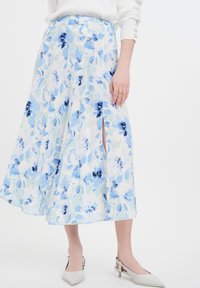 Blumen-Maxikleid in Hellblau und Grün, mit einem fließenden Design, seitlichen Schlitzen und einer glatten Stofftextur. Keine sichtbaren Metallteile.