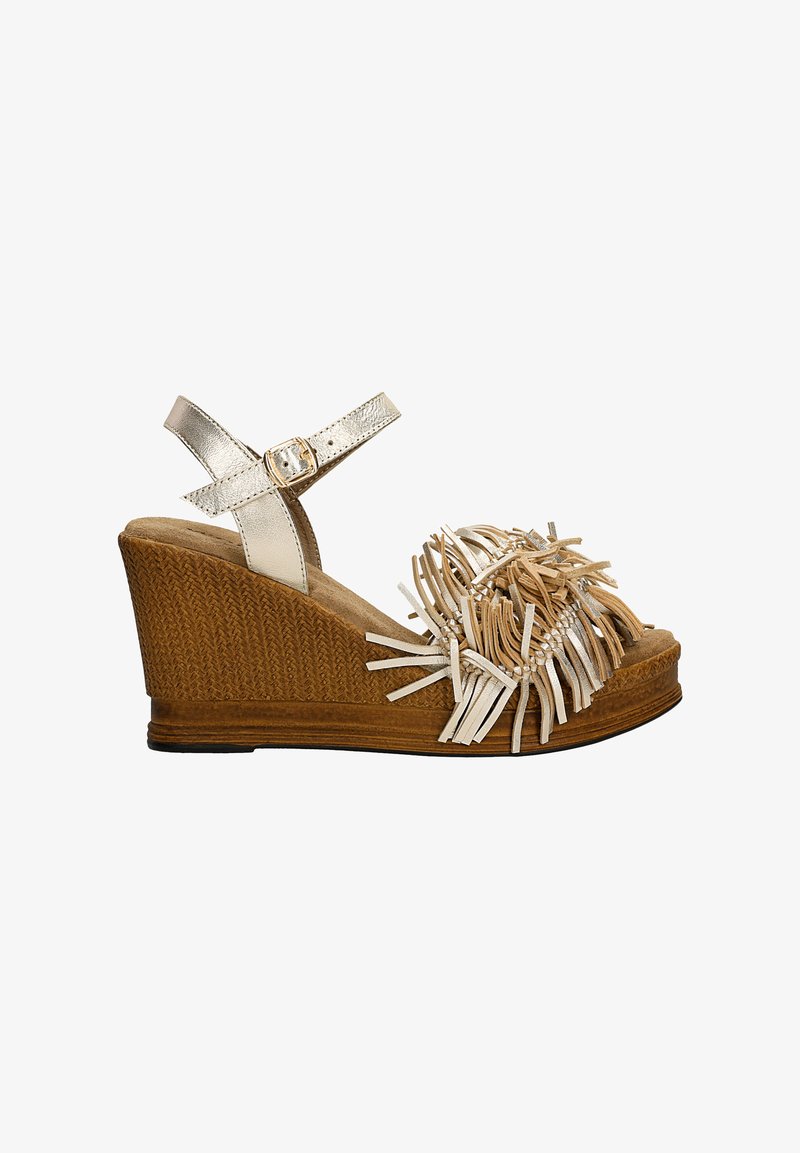 Sandały na koturnie z brązowym, plecionym podbiciem, metalicznie srebrnym paskiem na kostkę oraz ozdobnym frędzelkiem z jasnych pasków w okolicy palców.