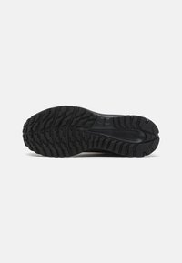 Semelle de chaussures en caoutchouc noire avec un motif de semelle texturé et multidirectionnel pour une meilleure adhérence. Sections renforcées et canaux de drainage.