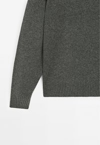 Maglione grigio a maglia con polsini e orlo a costine, caratterizzato da una texture morbida e una vestibilità rilassata. Design minimalista senza ulteriori motivi o accenti.