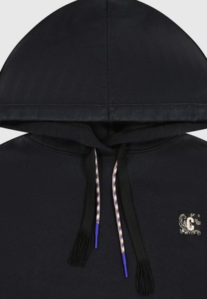 Zwarte hoodie met een trekkoord met paarse accenten en gestructureerde kwastjes, en een klein decoratief embleem aan de voorkant.