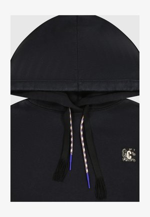 Schwarzer Hoodie mit einer Kordel zum Verstellen, lila Akzenten und texturierten Quasten sowie einem kleinen dekorativen Patch auf der Vorderseite.