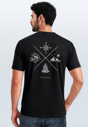 Mann blickt weg, trägt ein schwarzes T-Shirt mit Kompass-, Wellen-, Berg- und Lagerfeuersymbolen, die über dem Schriftzug "Neverless" auf dem Rücken gekreuzt sind.