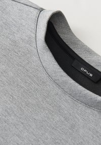 Felpa in cotone grigio con scollo rotondo. Presenta un collo interno nero e un'etichetta con la scritta "OPUS". Il materiale ha una consistenza liscia.