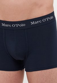 Boxer da uomo blu navy realizzati in tessuto morbido. Presentano un ampio elastico in vita con il logo "Marc O’Polo" in lettere argentate.