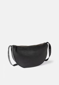 Black leather bag with a curved shape, featuring a zip closure and a flat shoulder strap. Textured surface with subtle grain detailing.