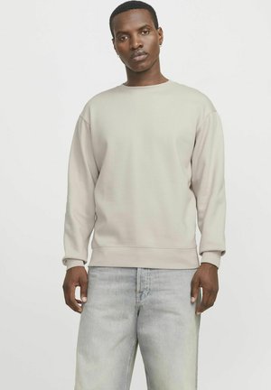 Light gray sweatshirt made of soft fabric, featuring a crew neckline and ribbed cuffs, paired with faded light blue jeans.
