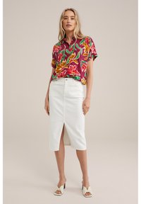 Cămașă florală cu mânecă scurtă în burgund, verde și galben; fustă din denim albă cu fanta frontală; purtată cu sandale cu toc gros de culoare deschisă.