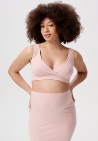 Lyserød ribbet crop top med V-hals og brede stropper, parret med en matchende ribbet nederdel. Stoffet har en glat, strækbar struktur.