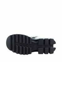 Czarna gumowa podeszwa o szorstkiej teksturze, z głębokimi bieżnikami i wypustkami. Projekt jest funkcjonalny pod względem przyczepności i trwałości.