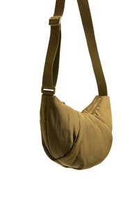 Borsa a spalla di tessuto marrone con forma curvata, dotata di una larga tracolla regolabile e texture morbida e imbottita. Design minimalista senza hardware visibile.