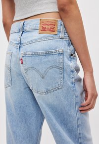 Φωτεινό μπλε τζιν με ευθεία γραμμή στο πόδι. Περιλαμβάνει δερμάτινο λογότυπο με επωνυμία και χαρακτηριστική ραφή στην πίσω τσέπη.