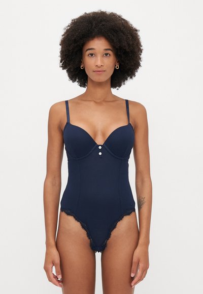 Navyblaues Bodysuit mit gerippter Textur, tiefem Ausschnitt, verstellbaren Trägern, drei Knöpfen in der Mitte und Spitzenbesatz an den Beinen.