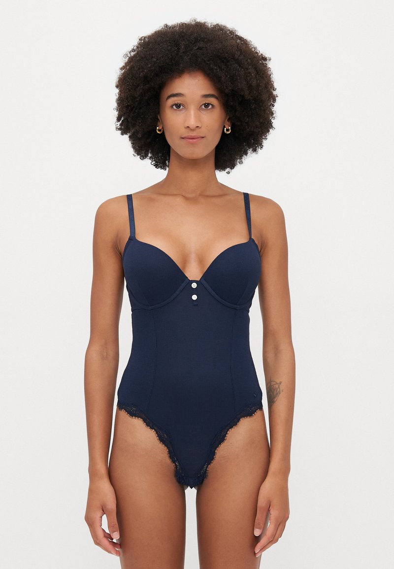 Body azul marinho com textura canelada, decote profundo, alças ajustáveis, três botões ao centro e rendas nas pernas.