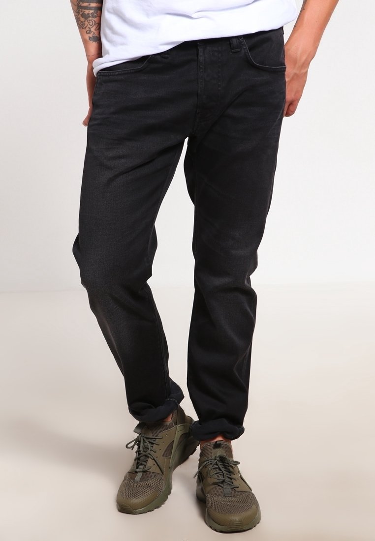 Svarta jeans i denim med slim fit, med en medelhög midja, framfickor och en mjuk textur. I kombination med olivgröna sportskor.