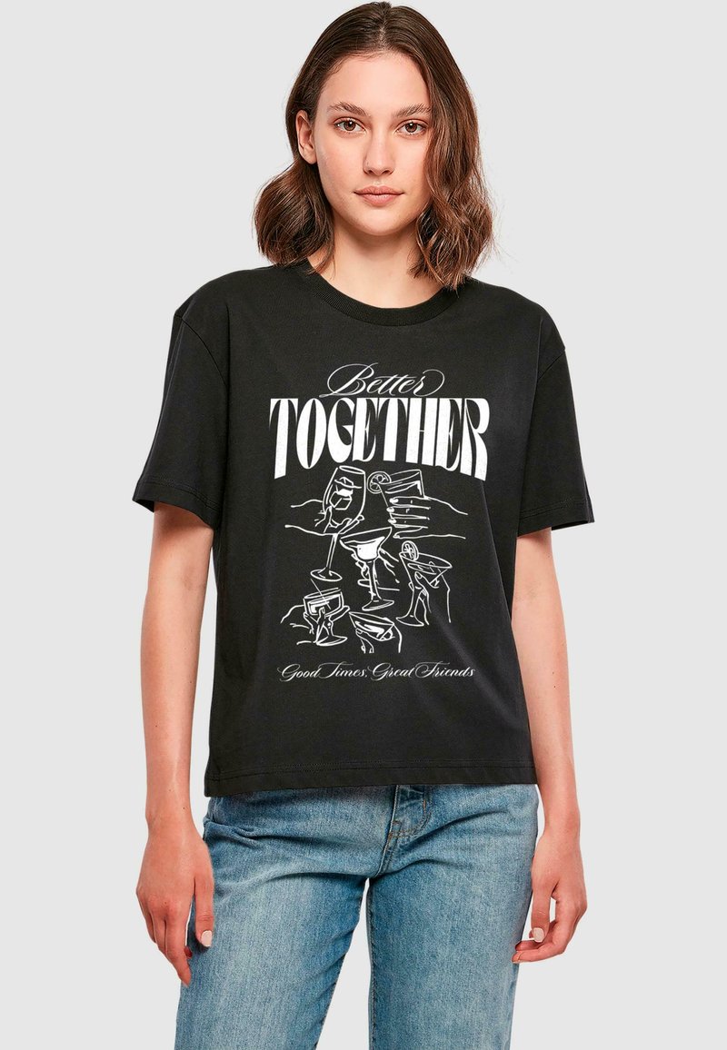 T-shirt noir en coton avec un design graphique incluant le texte blanc "Mieux ensemble" et des illustrations de boissons. Coupe décontractée avec des manches courtes.