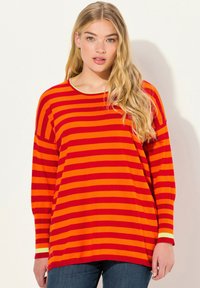Röd- och orange randig långärmad topp med rundad halsringning och kontrasterande ljusgrön kant, tillverkad av ett mjukt tyg.