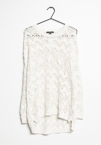 Weißer, gestrickter Pullover, der an einem Haken hängt. Mit Zickzackmuster, langen Ärmeln und einem runden Halsausschnitt mit Rippstrickabschluss.
