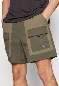 Πράσινα cargo σορτσάκια φτιαγμένα από ελαφρύ ύφασμα, με δύο μεγάλες μπροστινές τσέπες, το λογότυπο της Patagonia και σχέδιο σε αντίθεση.