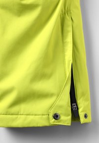 Veste imperméable jaune vif avec une ventilation latérale zippée et des boutons-pression, dotée d'un extérieur à texture lisse et de coutures piquées.