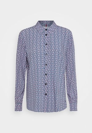 Chemise à manches longues boutonnée avec un motif géométrique bleu, blanc et rose et un col pointu.