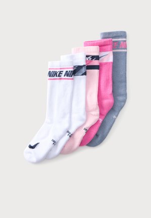Päť párov ponožiek Nike crew v bielej, svetlo ružovej, tmavo ružovej a šedej farbe, usporiadaných vedľa seba na svetlom pozadí.