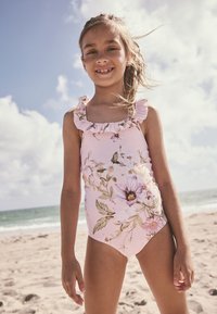 Costum de baie roz deschis cu modele florale; prezintă bretele cu volane pe umeri; fabricat din material neted, potrivit pentru plajă.