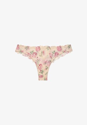 Culotte en dentelle crème avec un motif floral de roses roses et des bords festonnés, posée à plat sur un fond blanc.