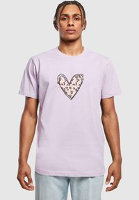 Camiseta de manga corta lavanda con un dise�ño de corazón con un patrón de leopardo delineado en negro, hecha de suave algodón.