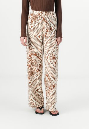Pantalons larges en tissu crème avec un motif floral et géométrique marron. Taille élastique et coupe ample pour le confort et le style.