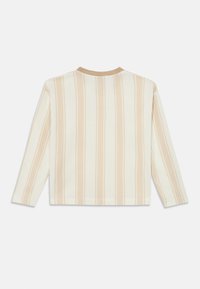 Μακρυμάνικο πλεκτό τοπ με κάθετες ρίγες σε μπεζ και κρεμ αποχρώσεις. Το σχέδιο διαθέτει στρογγυλή λαιμόκοψη και άνετη εφαρμογή. Υφή υφάσματος με υφή.