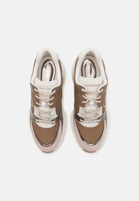 Baskets marron en mesh et cuir lisse, avec des accents crème, des textures contrastées, des lacets ronds et un logo sur la languette.