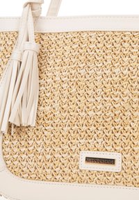 Sac à main en paille tissée avec des accents en cuir crème et un pompon. Présente une plaque logo à la base. Surface texturée et couleur neutre.