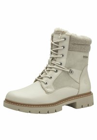 Bottes de cheville imperméables beige avec un bout en cuir lisse, des panneaux en daim et un col doublé en laine. Présente un système de laçage et une semelle robuste.