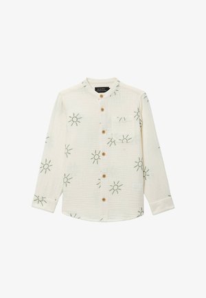 Chemise crème à manches longues avec col rond, boutons en bois sur le devant, poche poitrine et motif de broderie verte en forme de soleil.