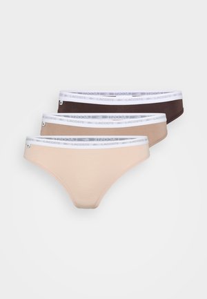 Drie paar stringondergoed in beige, lichtbruin en donkerbruin. Elk heeft een witte tailleband met het Lacoste-logo. Soepele stof.